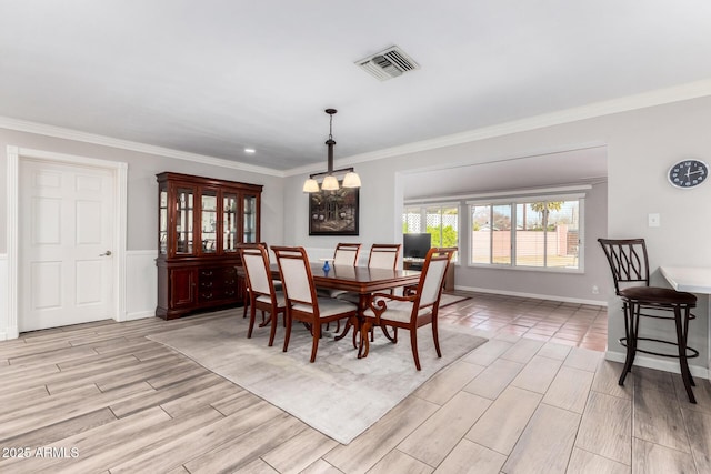 dining area with crown molding and a chandelier