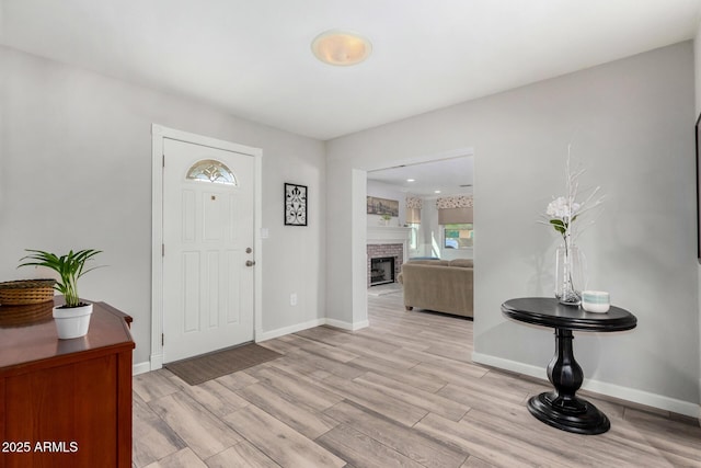 entrance foyer featuring a fireplace and light wood-type flooring