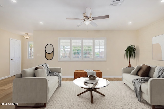 living room with light hardwood / wood-style floors and ceiling fan