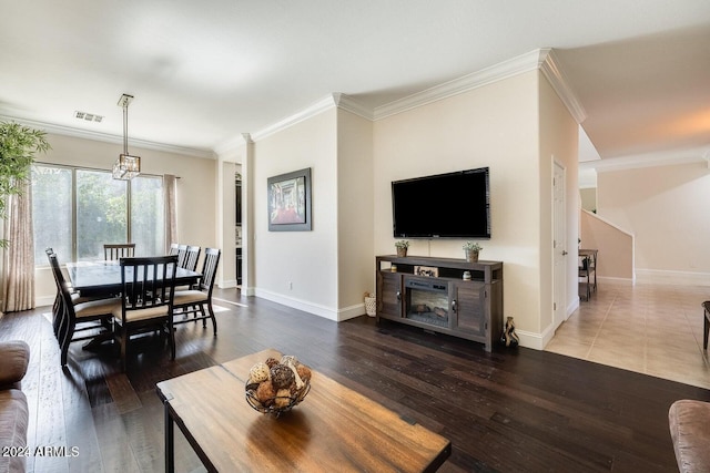 living room with visible vents, crown molding, baseboards, and hardwood / wood-style floors