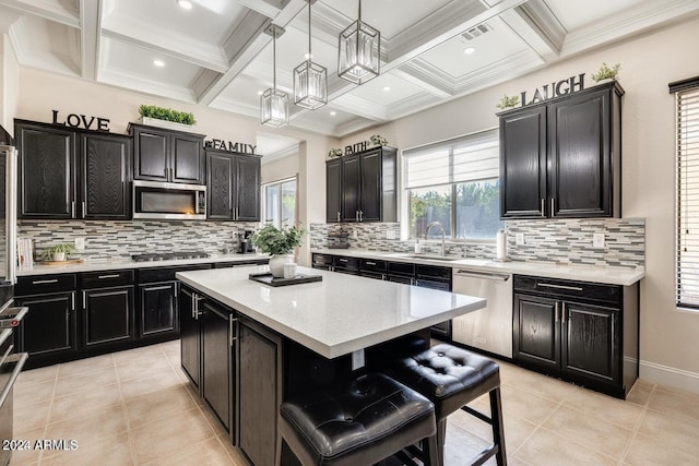 kitchen with visible vents, a sink, a center island, stainless steel appliances, and dark cabinets