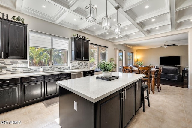 kitchen with beamed ceiling, coffered ceiling, dark cabinets, and a center island