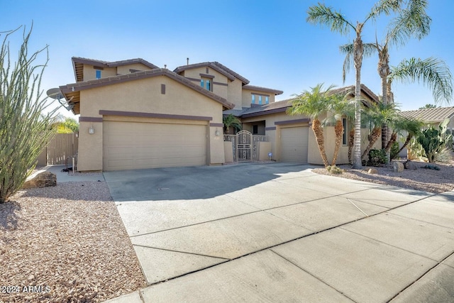 view of front of property featuring fence, concrete driveway, stucco siding, an attached garage, and a gate