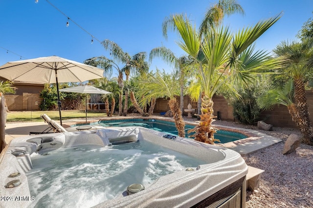 view of pool featuring a hot tub and a fenced backyard