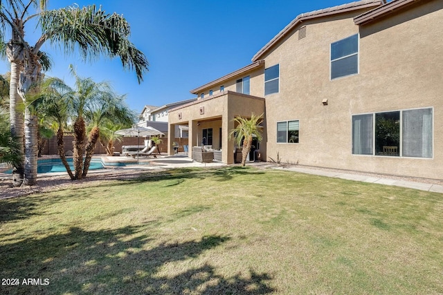 back of property featuring a fenced in pool, fence, stucco siding, a lawn, and a patio area