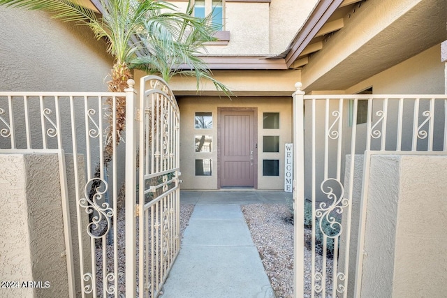 property entrance featuring a gate and stucco siding