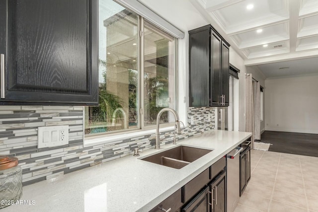 kitchen featuring light tile patterned floors, coffered ceiling, a sink, crown molding, and tasteful backsplash