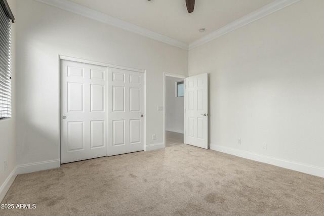 unfurnished bedroom with a closet, baseboards, carpet, and ornamental molding