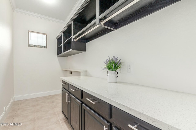 kitchen with ornamental molding, open shelves, light tile patterned flooring, baseboards, and light stone countertops