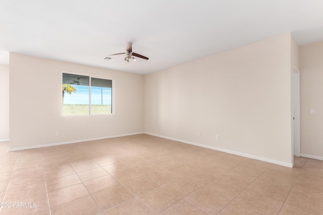 spare room with ceiling fan and light tile patterned floors