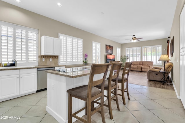 925 W San Marcos Dr, Chandler, AZ 85225 - kitchen with dishwasher, light tile patterned floors, electric cooktop, a ceiling fan, and a kitchen bar