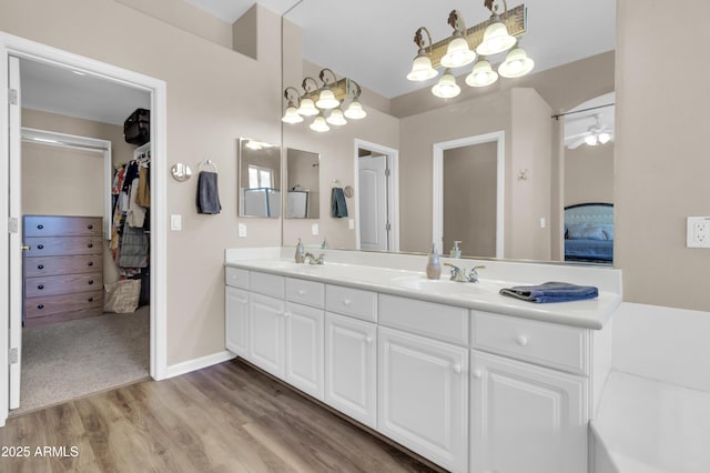 925 W San Marcos Dr, Chandler, AZ 85225 - bathroom with double vanity, wood finished floors, a walk in closet, a chandelier, and a ceiling fan