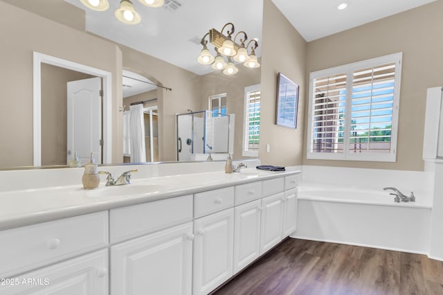 925 W San Marcos Dr, Chandler, AZ 85225 - bathroom featuring double vanity, a shower stall, a bath, wood finished floors, and a chandelier