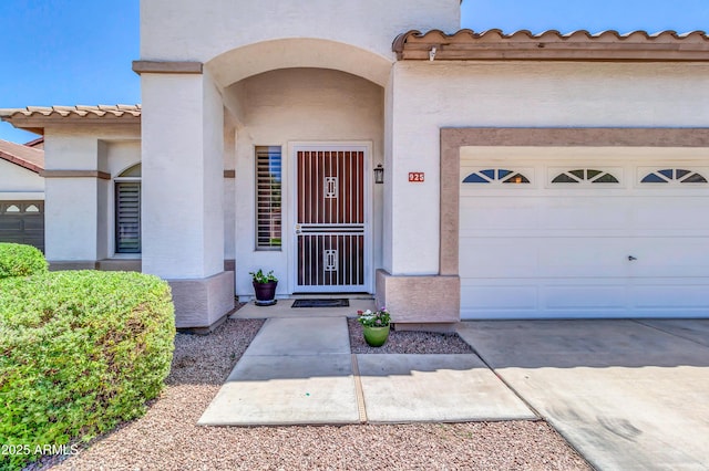 925 W San Marcos Dr, Chandler, AZ 85225 - doorway to property featuring stucco siding, a tiled roof, a garage, and concrete driveway