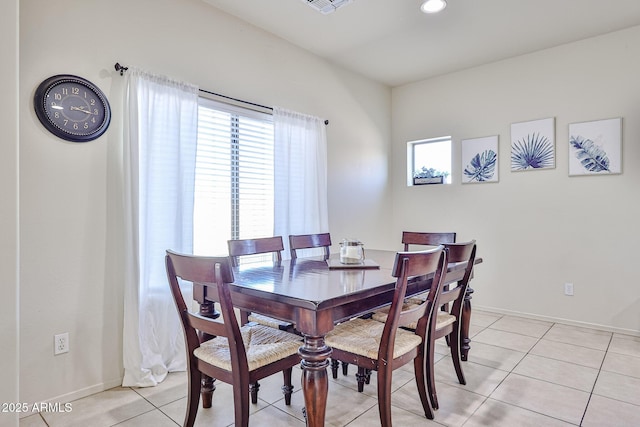 dining room featuring baseboards, a wealth of natural light, and light tile patterned flooring