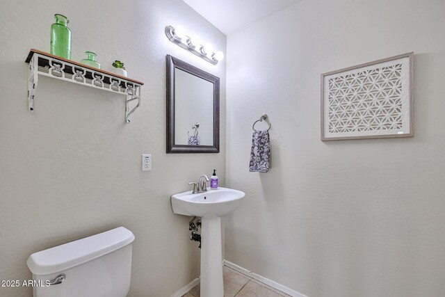 bathroom featuring baseboards, toilet, and tile patterned floors