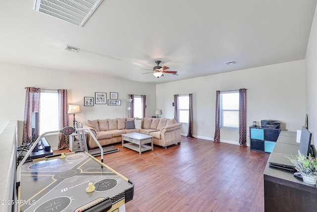 living area featuring wood finished floors, visible vents, and a ceiling fan