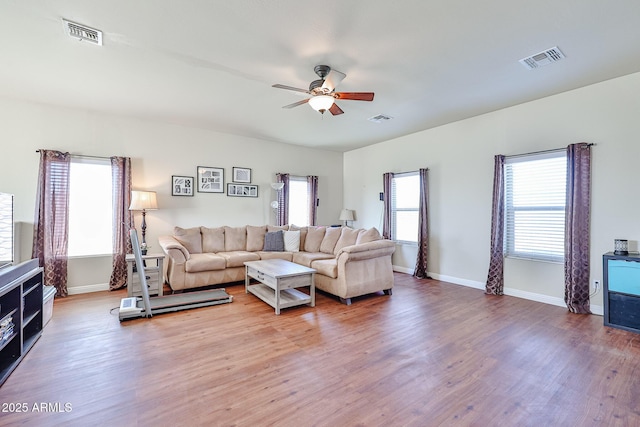 living area featuring visible vents, ceiling fan, and wood finished floors