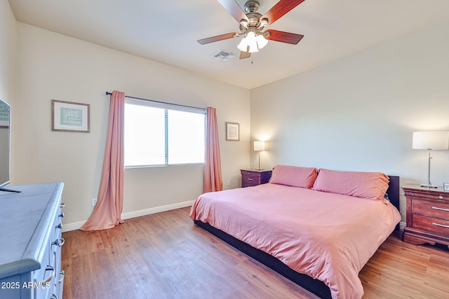 bedroom with light wood-type flooring, baseboards, visible vents, and a ceiling fan