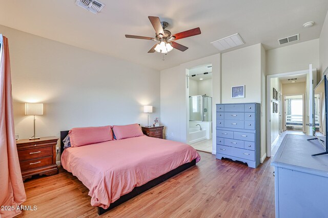 bedroom with ceiling fan, light wood finished floors, ensuite bath, and visible vents