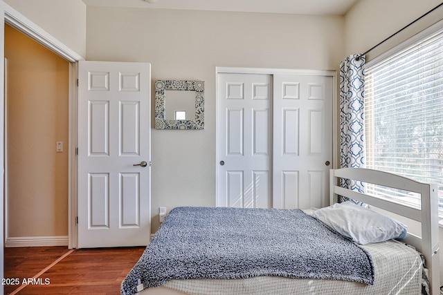 bedroom featuring baseboards, a closet, and wood finished floors