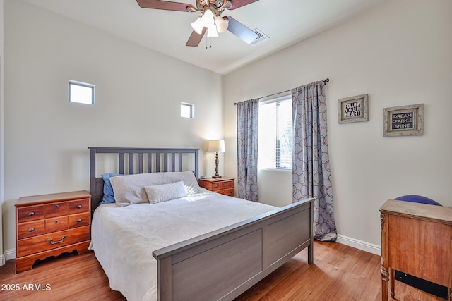 bedroom with light wood-style floors, baseboards, visible vents, and ceiling fan