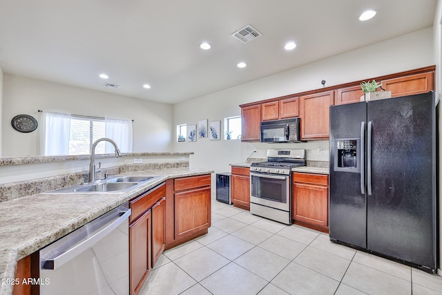 kitchen featuring light countertops, a sink, and black appliances