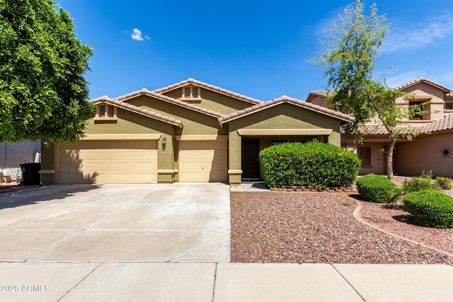 12814 W Indianola Ave, Avondale, AZ 85392 - view of front of property featuring an attached garage, a tiled roof, concrete driveway, and stucco siding