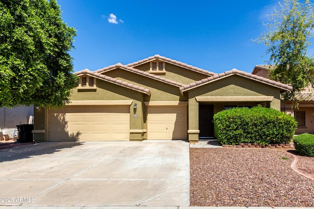 12814 W Indianola Ave, Avondale, AZ 85392 - view of front of home featuring a tiled roof, an attached garage, driveway, and stucco siding