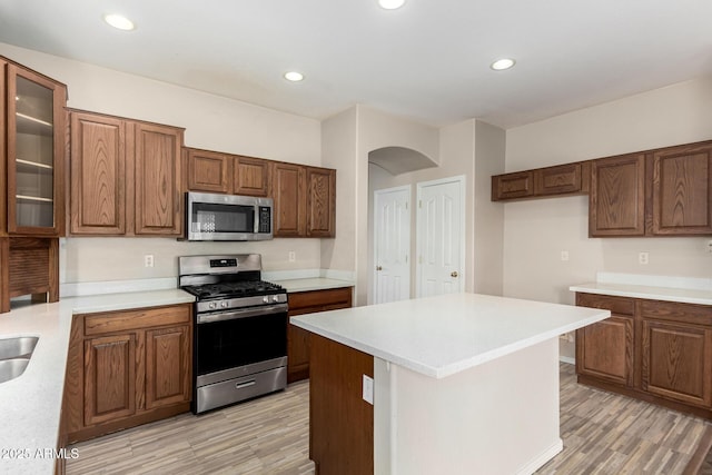 12814 W Indianola Ave, Avondale, AZ 85392 - kitchen featuring light wood-style floors, light countertops, glass insert cabinets, and stainless steel appliances