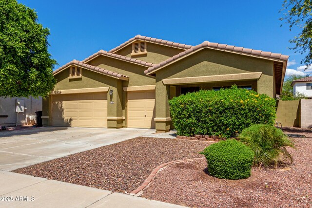 12814 W Indianola Ave, Avondale, AZ 85392 - craftsman-style home featuring concrete driveway, an attached garage, a tiled roof, and stucco siding