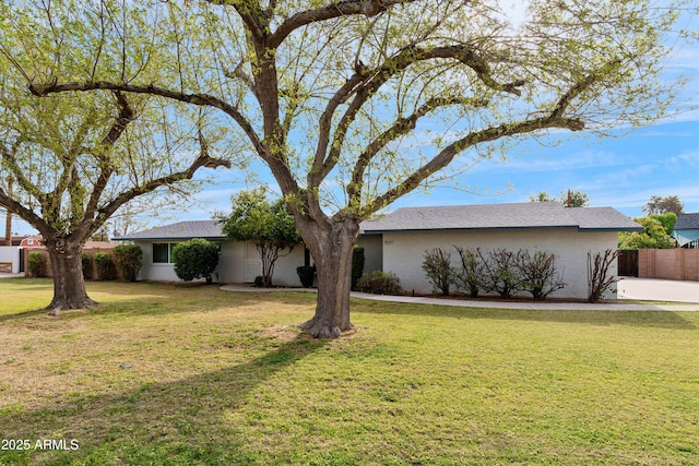 ranch-style house featuring stucco siding, fence, and a front yard