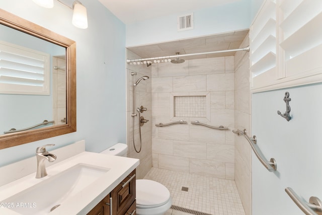 full bath featuring visible vents, vanity, a tile shower, and toilet
