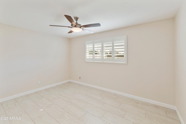 empty room featuring ceiling fan and baseboards