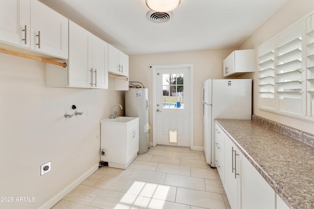 laundry area featuring visible vents, baseboards, electric dryer hookup, and water heater