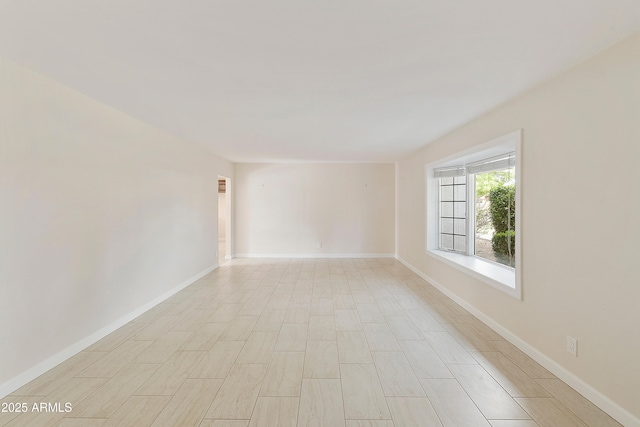 unfurnished room with baseboards