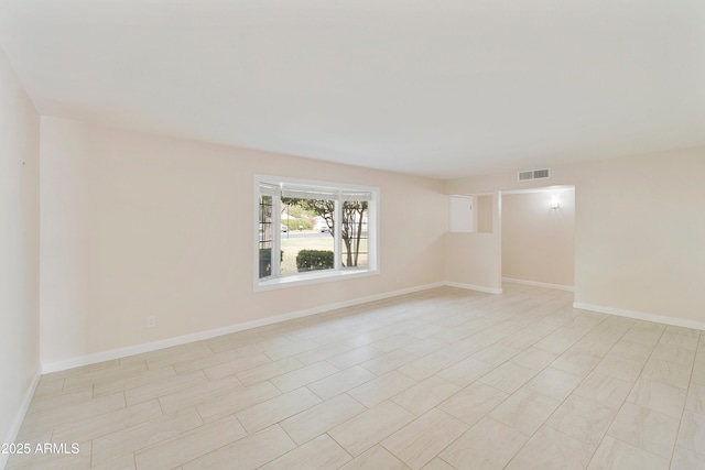 spare room featuring visible vents and baseboards
