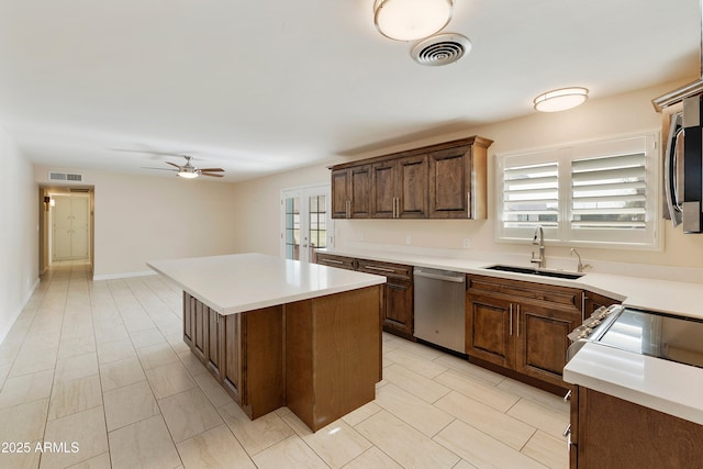 kitchen with a kitchen island, visible vents, appliances with stainless steel finishes, and a sink
