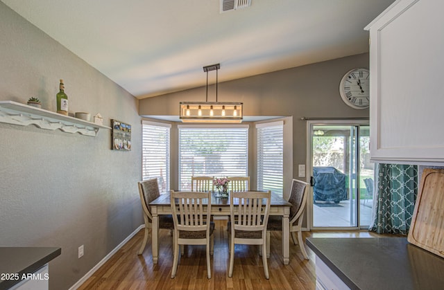 dining space featuring lofted ceiling, light wood-style floors, visible vents, and baseboards