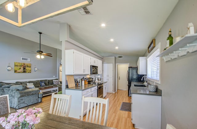 kitchen featuring stainless steel electric range oven, white cabinets, visible vents, and black microwave