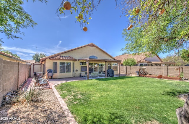 back of property with a yard, a fenced backyard, stucco siding, a tile roof, and a patio area