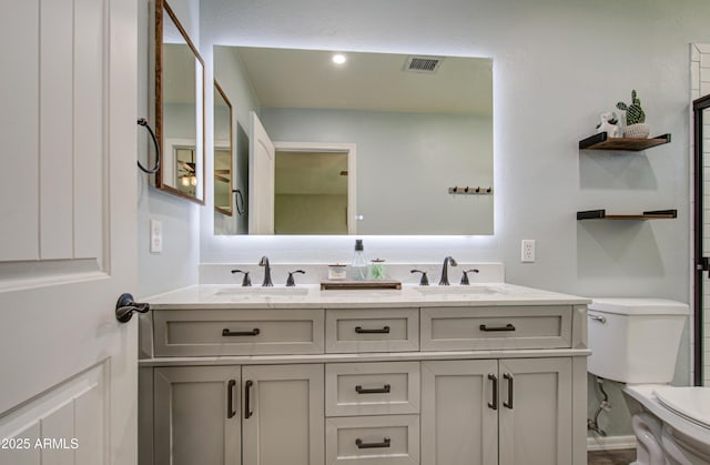 full bathroom featuring double vanity, visible vents, toilet, and a sink