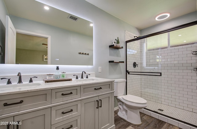 full bath featuring a sink, visible vents, toilet, and a shower stall