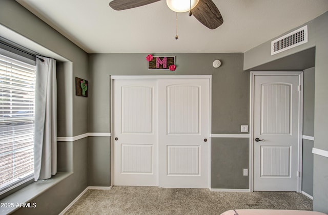 unfurnished bedroom with visible vents, multiple windows, carpet, and a closet