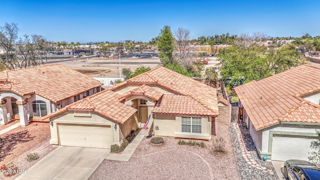 view of front of house featuring fence, a tile roof, concrete driveway, stucco siding, and an attached garage