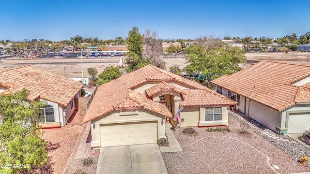 view of front of house featuring stucco siding, concrete driveway, a tile roof, and a garage