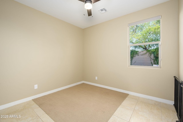empty room featuring light tile patterned floors, baseboards, a ceiling fan, and visible vents
