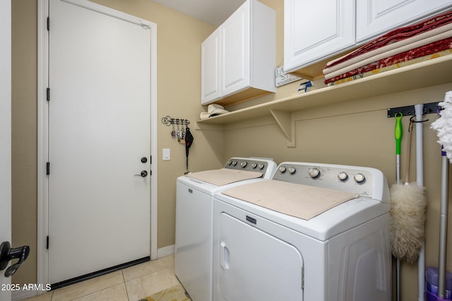 laundry room with light tile patterned floors, washing machine and dryer, baseboards, and cabinet space