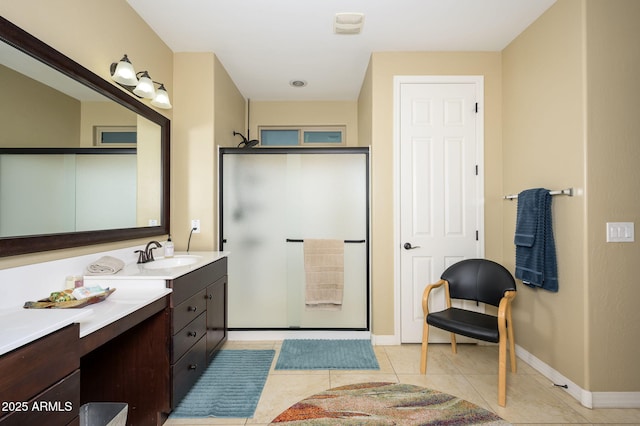 bathroom featuring a stall shower, vanity, baseboards, and tile patterned flooring