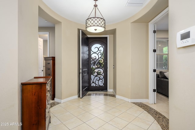 entryway with light tile patterned floors, baseboards, and visible vents
